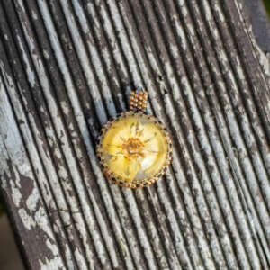 Wisiorek obszywany z żółtym kwiatem