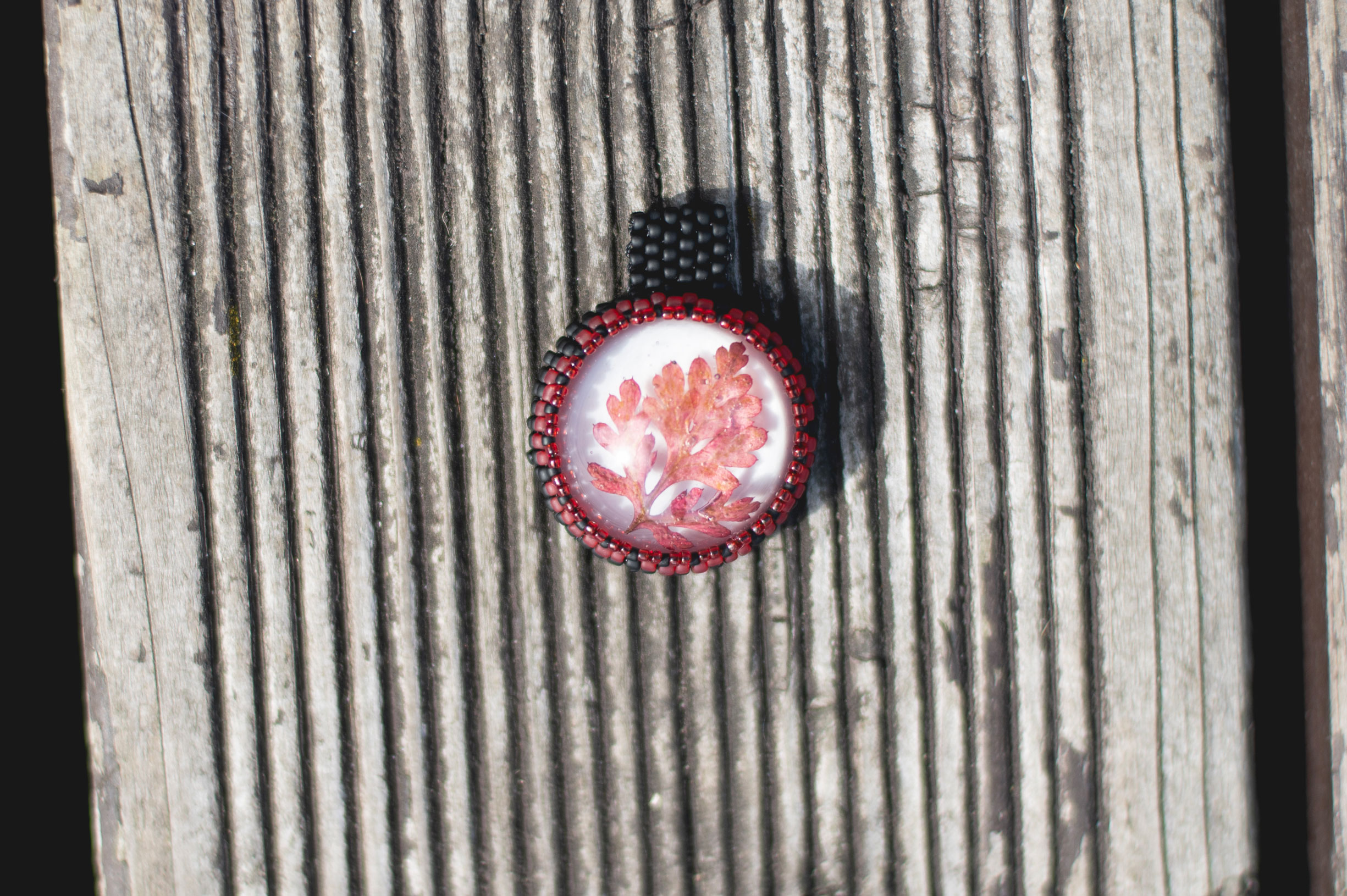 Wisiorek obszywany z czerwonym listkiem